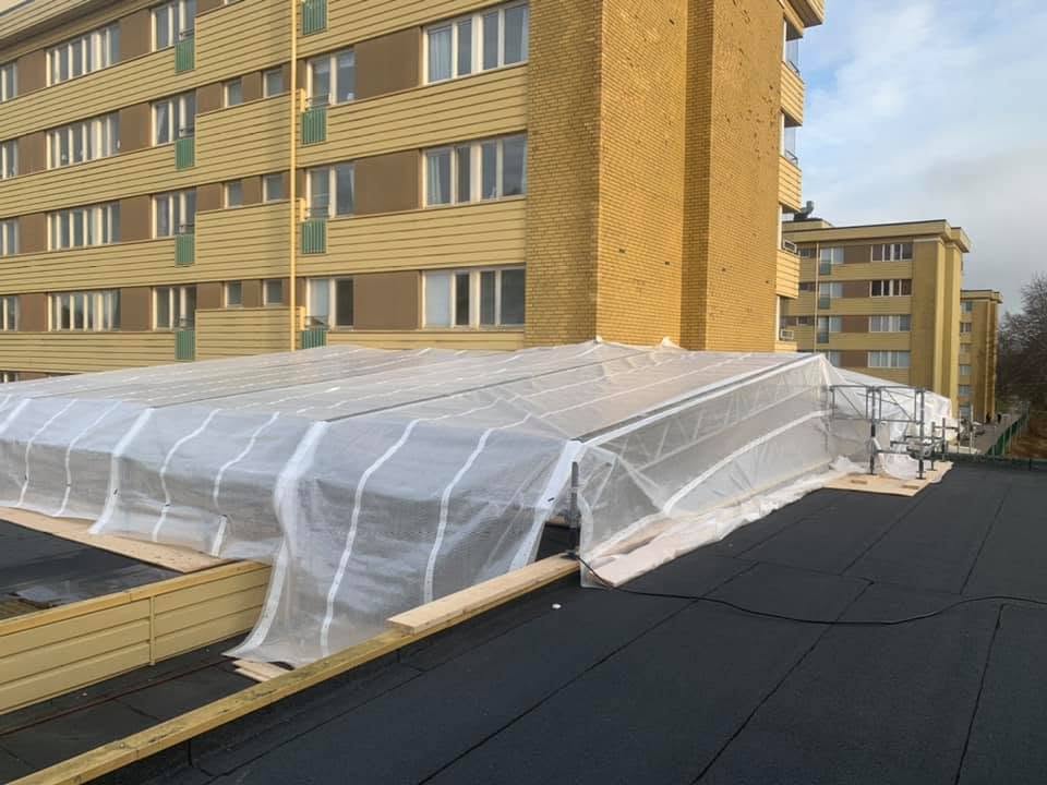Litet väderskydd i plast över ett tak vid byte av papptak
